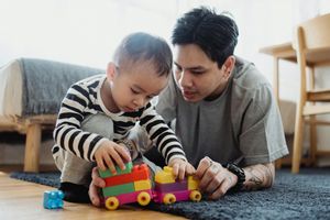 Man Playing with Toys with a Baby Boy on Carpet