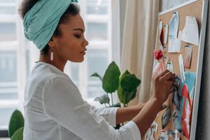 Woman in White Long Sleeve Shirt Holding Pink and White Floral Textile